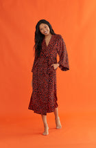 A lady wearing a long sleeve maxi robe with rustic animal pattern.