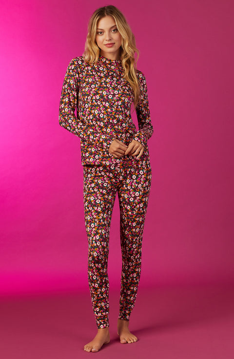 A lady wearing a long sleeve gemma pj set with disty floral pattern.