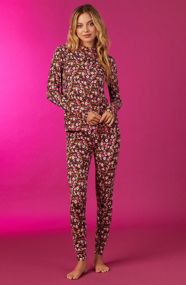A lady wearing a long sleeve gemma pj set with disty floral pattern.