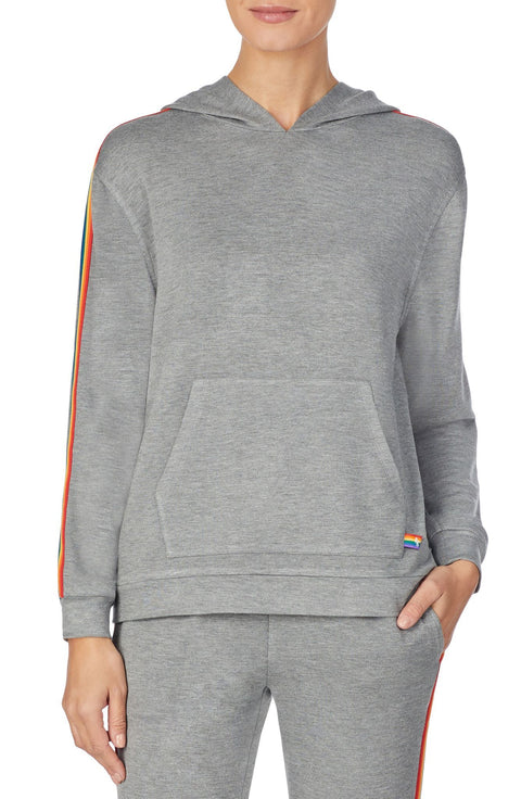 A lady wearing a grey long sleeve unisex reese hoodie with pride stripes in side.