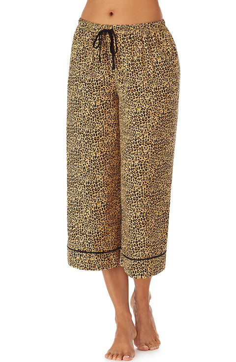 Bottom part f a girl wearing a crop pant with leopard skin pattern.